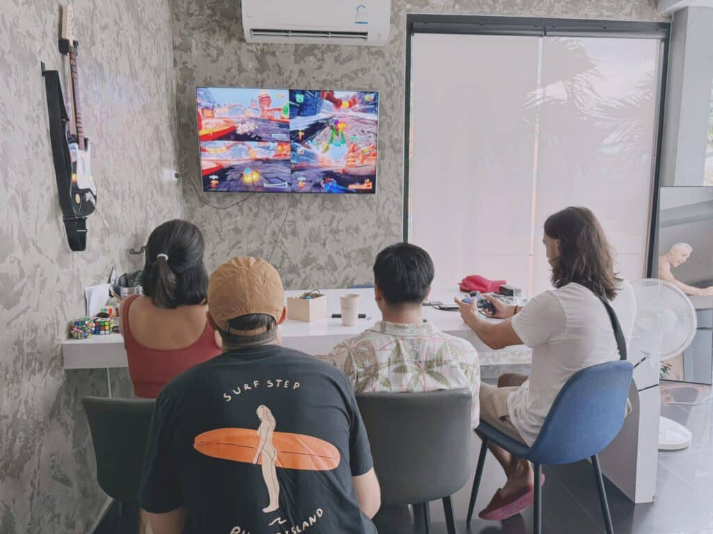 Fellow divers and travelers relaxing and playing video games at Tall Tree Kata Phuket.